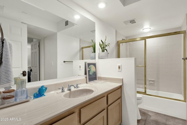 bathroom featuring shower / bath combination with glass door, visible vents, toilet, vanity, and tile patterned flooring