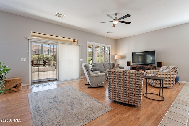 living room featuring ceiling fan, a healthy amount of sunlight, and light wood-type flooring