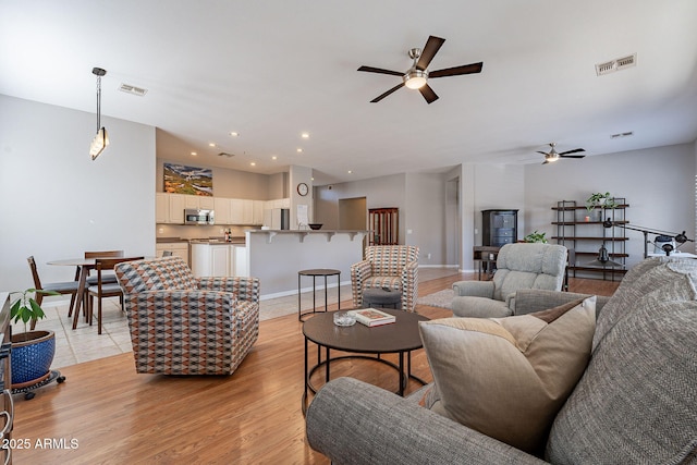 living room featuring ceiling fan and light wood-type flooring