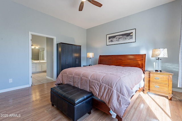 bedroom with ceiling fan, light wood-type flooring, and connected bathroom