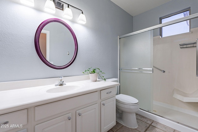 bathroom with tile patterned floors, vanity, toilet, and walk in shower