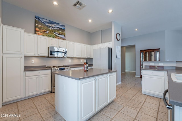 kitchen featuring a center island, stainless steel appliances, white cabinetry, and sink