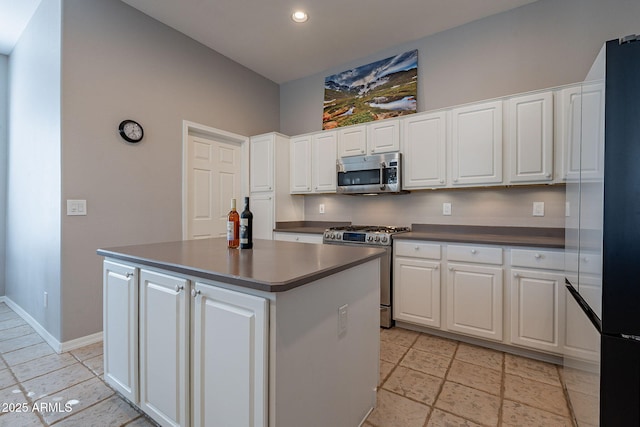 kitchen with a kitchen island, white cabinets, and appliances with stainless steel finishes