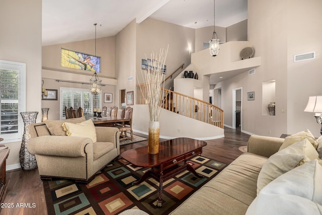 living room featuring a notable chandelier, visible vents, stairway, wood finished floors, and baseboards