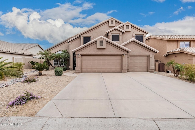 view of front of house with stucco siding, concrete driveway, and a tiled roof