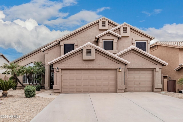 view of front of home featuring a garage, driveway, a tiled roof, and stucco siding