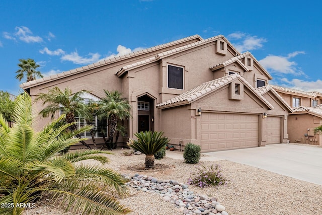 view of front of property with concrete driveway, a tile roof, and stucco siding