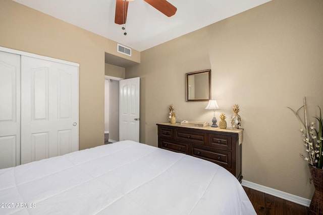 bedroom featuring ceiling fan, dark wood-type flooring, visible vents, baseboards, and a closet