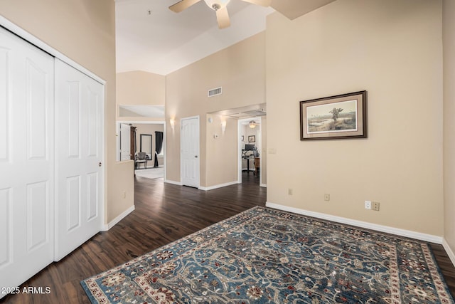 interior space with visible vents, a ceiling fan, vaulted ceiling, wood finished floors, and baseboards