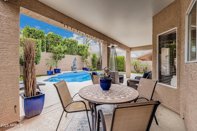 view of patio featuring outdoor dining space, a fenced backyard, and a fenced in pool