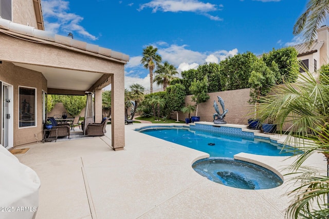 view of pool with a pool with connected hot tub, a fenced backyard, and a patio