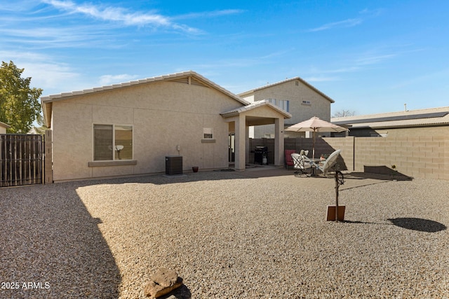 rear view of property featuring central AC and a patio area