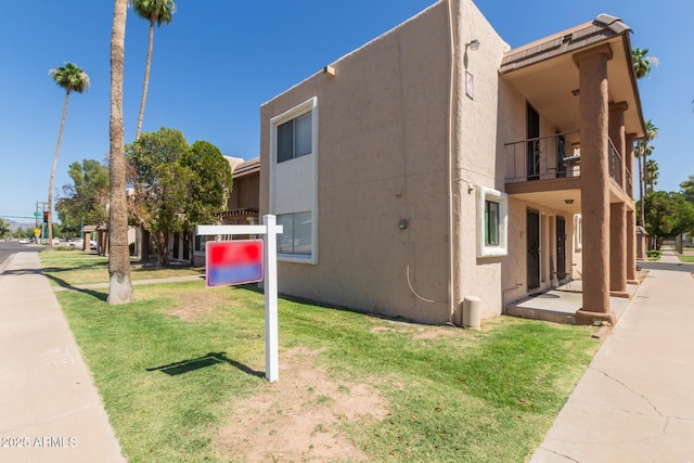 7126 N 19th Ave Unit 152, Phoenix, AZ 85021 - view of home's exterior featuring a balcony, a yard, and stucco siding
