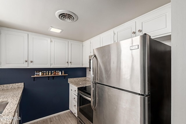 7126 N 19th Ave Unit 152, Phoenix, AZ 85021 - kitchen with stainless steel appliances, light wood-type flooring, white cabinets, light stone counters, and open shelves