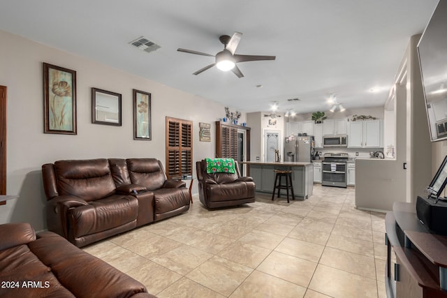 tiled living room featuring ceiling fan and sink