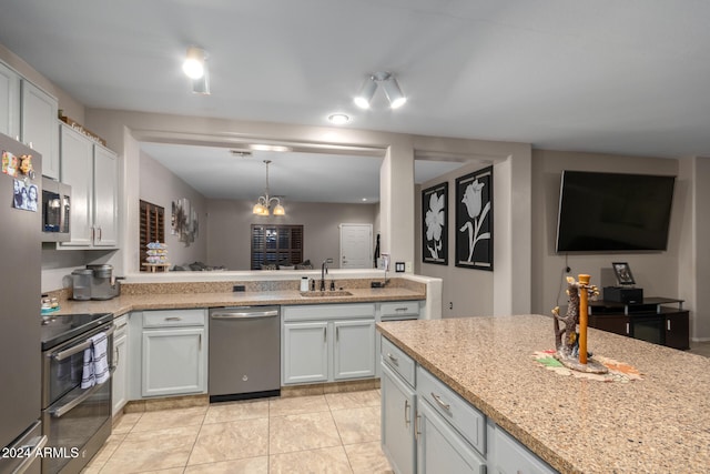 kitchen with white cabinetry, sink, a notable chandelier, light tile patterned floors, and appliances with stainless steel finishes