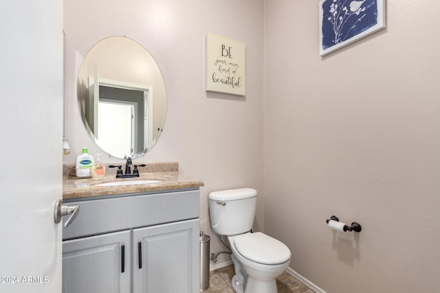 bathroom with tile patterned flooring, vanity, and toilet