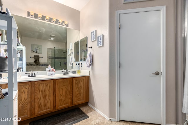 bathroom with tile patterned flooring, vanity, and a shower with door