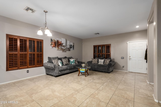 tiled living room featuring a chandelier