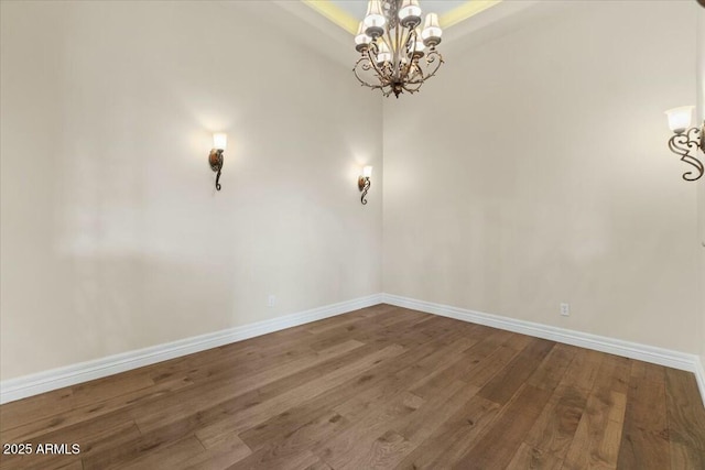 unfurnished room featuring hardwood / wood-style flooring and an inviting chandelier