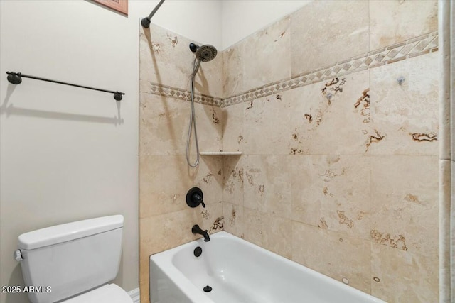 bathroom with tiled shower / bath combo and toilet