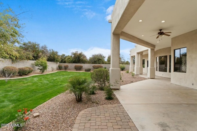 view of yard featuring a patio area and ceiling fan