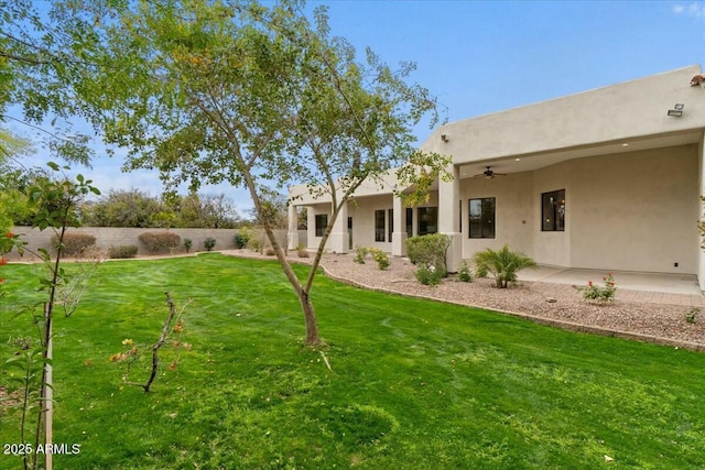 view of yard with ceiling fan and a patio