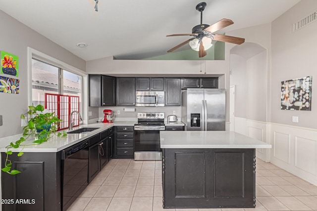 kitchen with lofted ceiling, sink, light tile patterned floors, ceiling fan, and stainless steel appliances