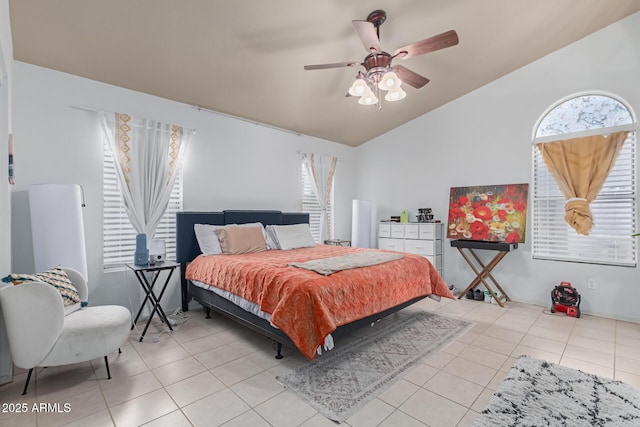 bedroom with light tile patterned floors, vaulted ceiling, and ceiling fan