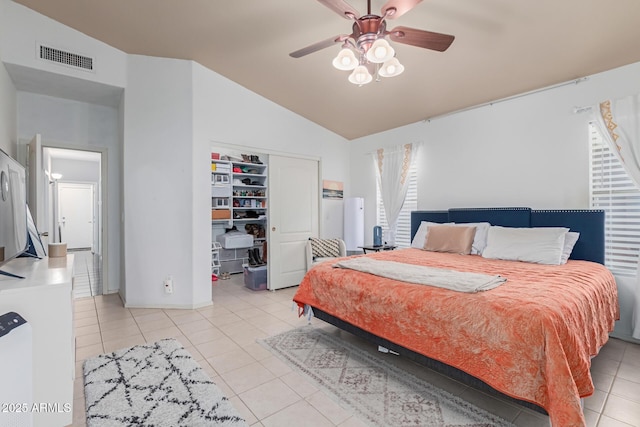 bedroom with lofted ceiling, light tile patterned floors, ceiling fan, a spacious closet, and a closet