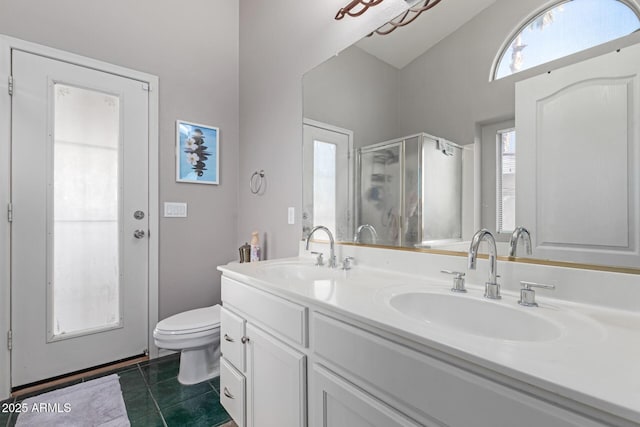 bathroom featuring tile patterned flooring, vanity, walk in shower, and toilet