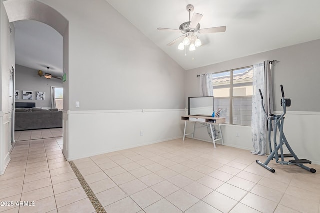 tiled empty room with vaulted ceiling and ceiling fan