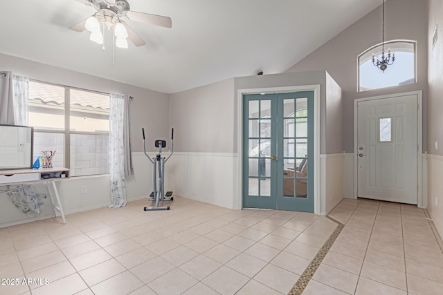 interior space with ceiling fan with notable chandelier, light tile patterned floors, and french doors