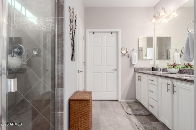 bathroom featuring tile patterned flooring, vanity, and walk in shower