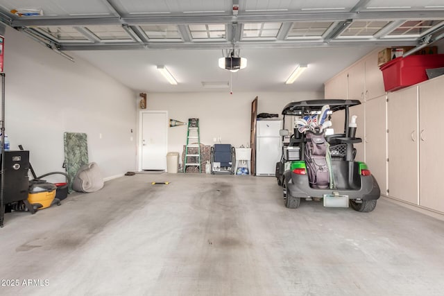 garage with white refrigerator and a garage door opener