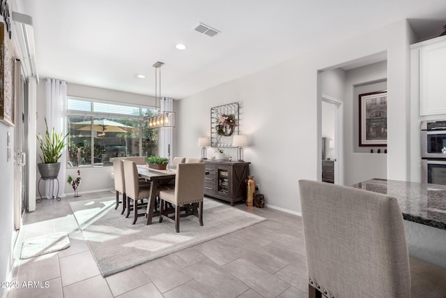 tiled dining space with an inviting chandelier