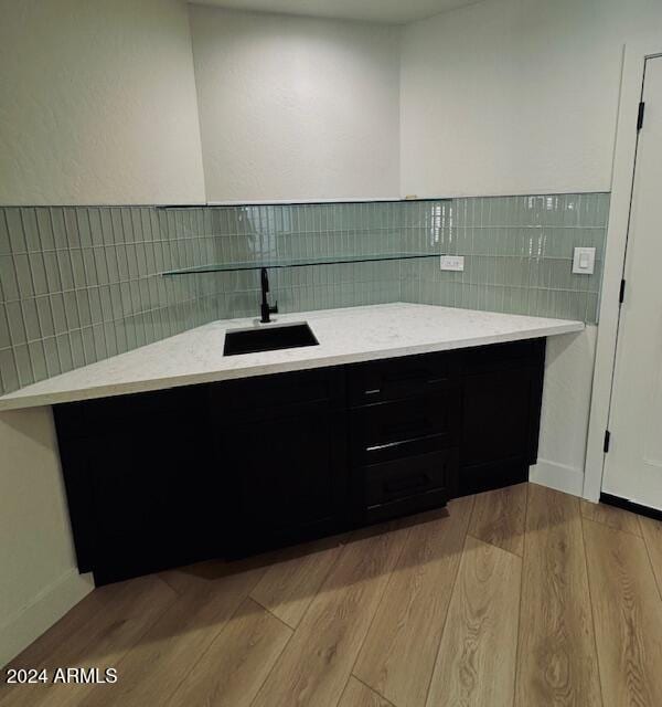 bathroom with wood-type flooring, sink, and tasteful backsplash