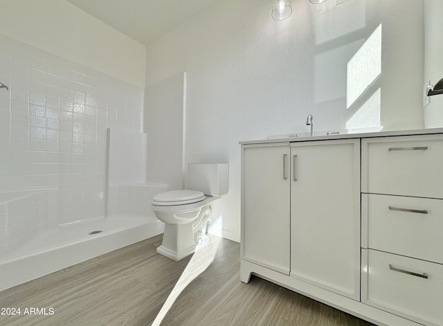 bathroom featuring a shower, toilet, vanity, and hardwood / wood-style flooring