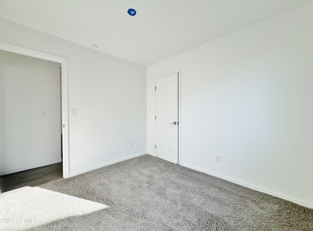 empty room featuring dark colored carpet