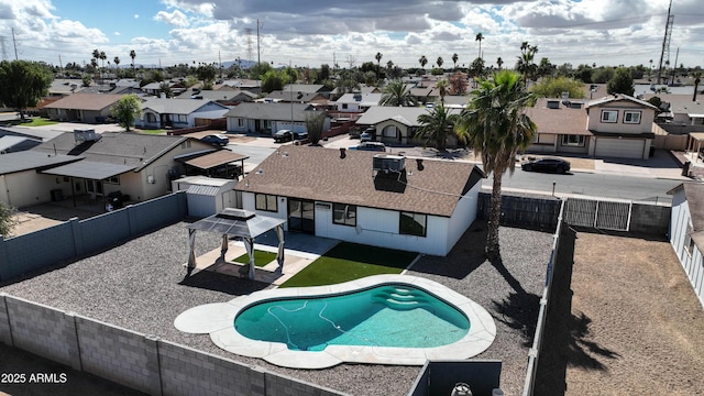 view of swimming pool featuring a patio, a fenced backyard, and a residential view