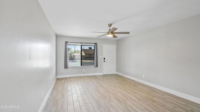 empty room with light wood-style flooring, baseboards, and a ceiling fan