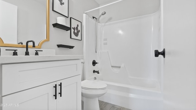 bathroom featuring toilet, vanity, wood finished floors, and bathing tub / shower combination