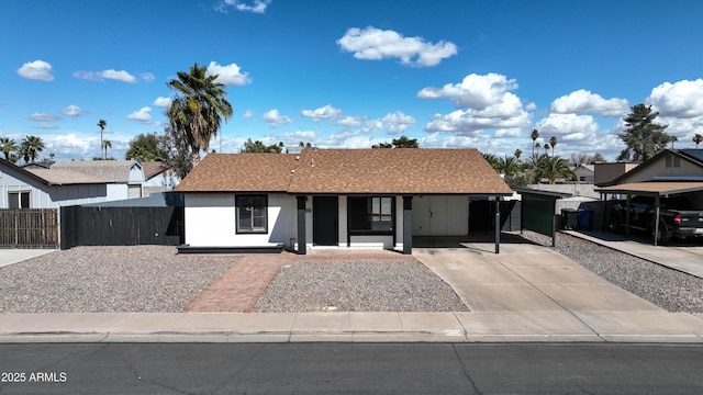 view of front facade with a porch, concrete driveway, roof with shingles, and fence