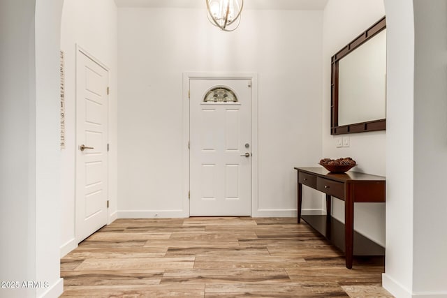 foyer with light hardwood / wood-style floors and a notable chandelier