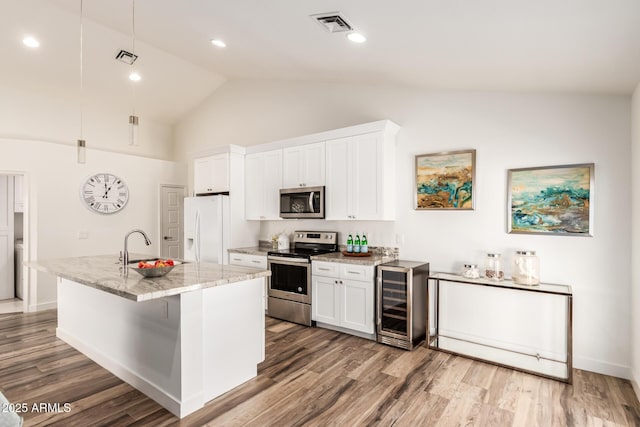 kitchen featuring stainless steel appliances, white cabinetry, and beverage cooler