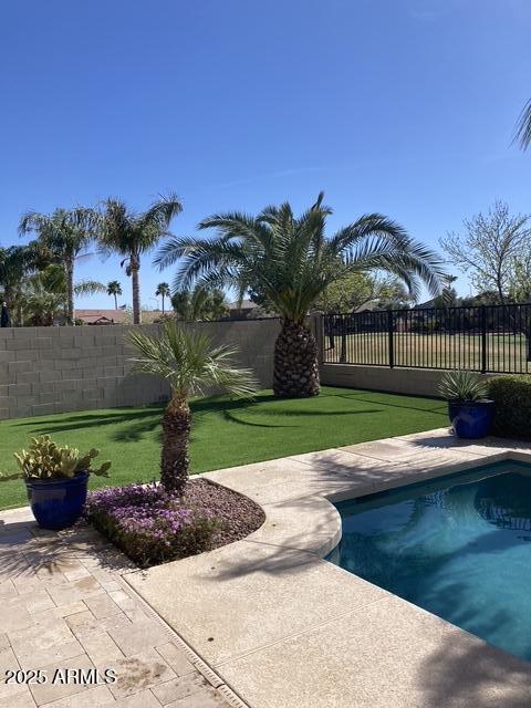 view of swimming pool with a patio and a lawn