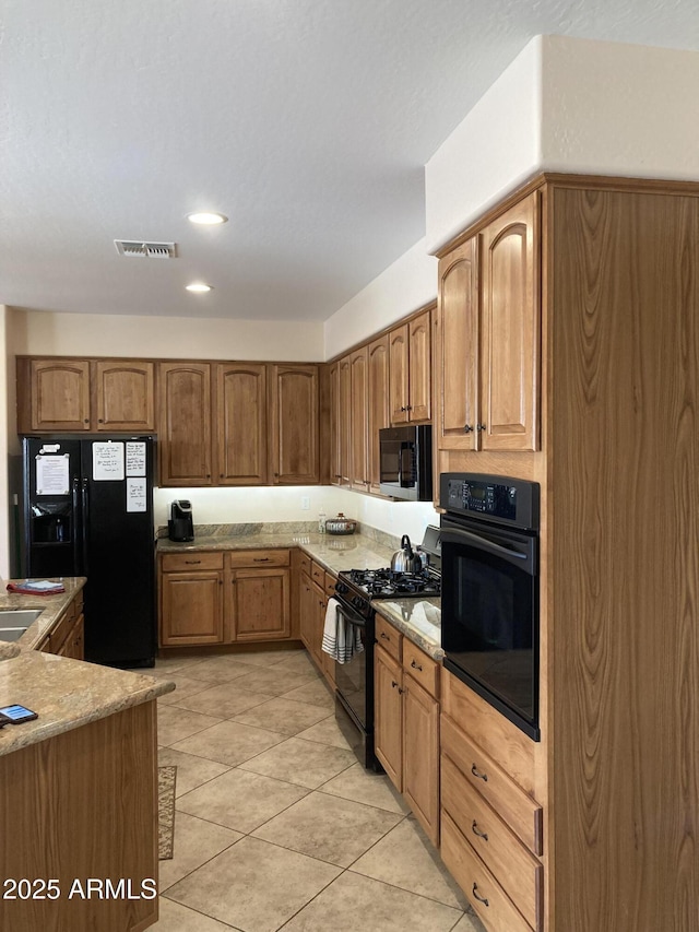 kitchen with sink, black appliances, and light tile patterned flooring