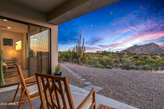 patio terrace at dusk featuring a mountain view