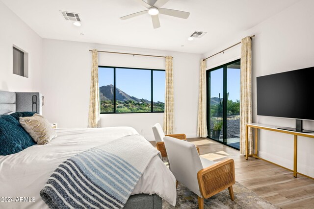 bedroom with access to exterior, multiple windows, ceiling fan, and light hardwood / wood-style floors