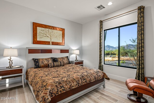 bedroom featuring light hardwood / wood-style floors and a mountain view